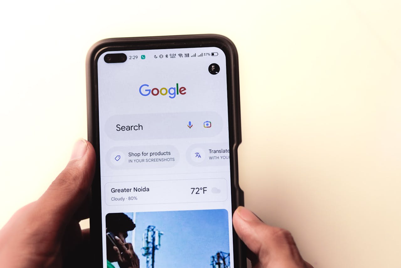 A person holds a smartphone displaying the Google search homepage, showing search options, weather, and other features on the screen. Top 10 SEO Developments November 2025 for Financial Brands: Nov 13, 2025