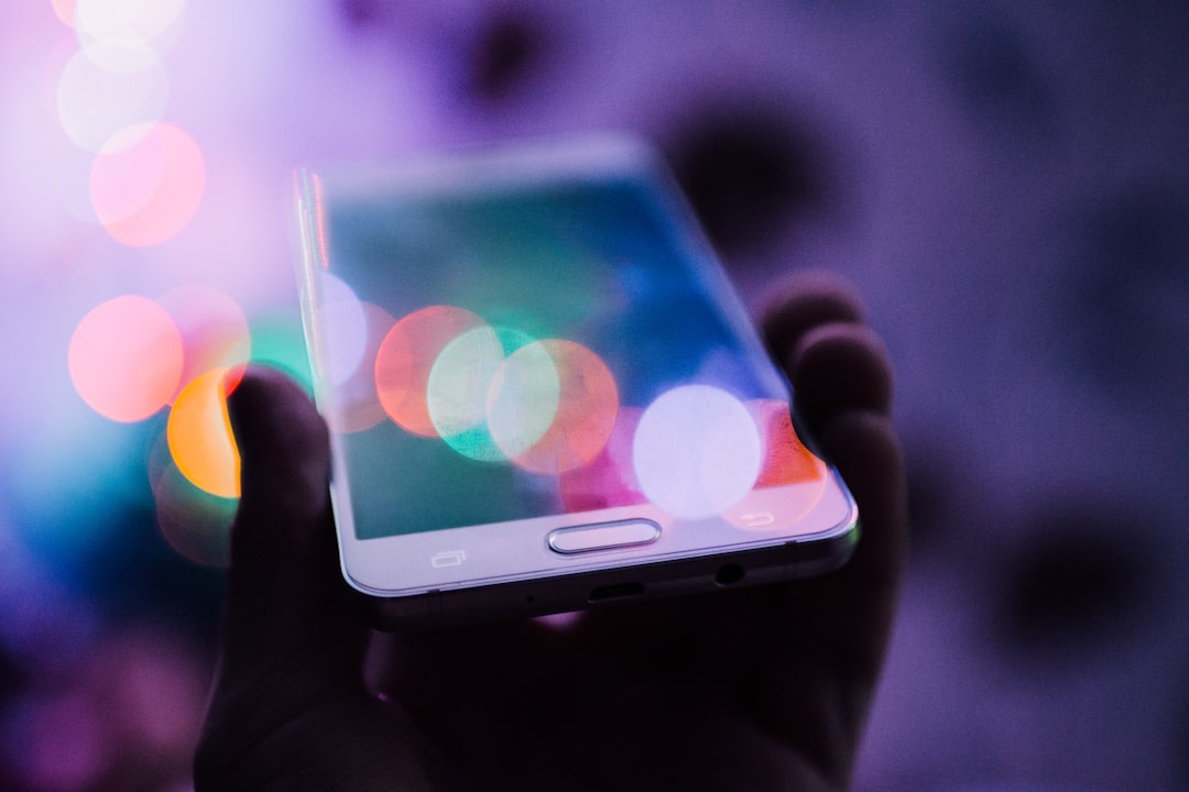 A hand holds a smartphone with a blurred, colorful bokeh background, symbolizing the innovation and connectivity driven by modern fintech models.