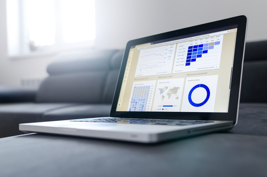 An open laptop displaying charts and graphs on screen illustrates the transformative power of AI in finance, revolutionizing personal finance management. It's placed on a gray surface, signifying the blend of technology with everyday life for smarter financial decisions.