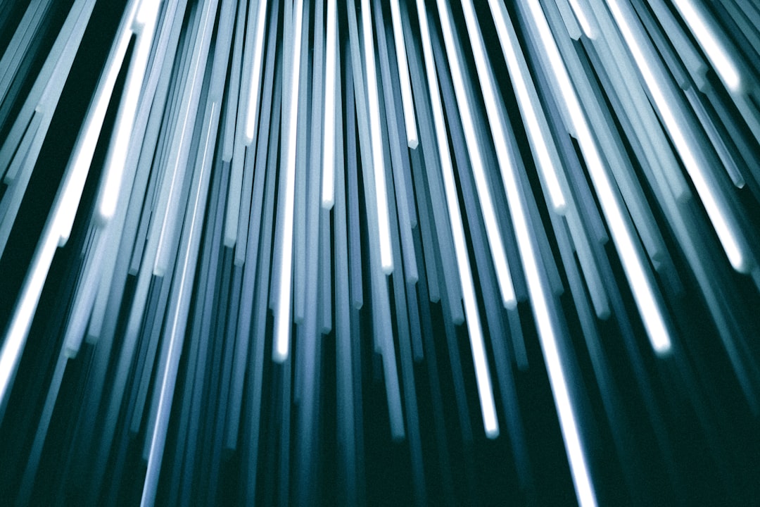 Streaks of white light form a dynamic, vertical pattern against a dark background, evoking the essence of digital abstract design, much like the synergy found in tech partnerships.