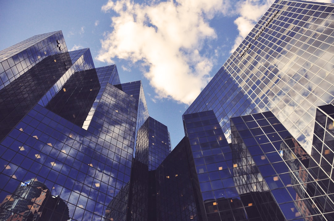 Tall, reflective glass skyscrapers rise against the partly cloudy sky, symbolizing mutual benefits of urban collaboration.