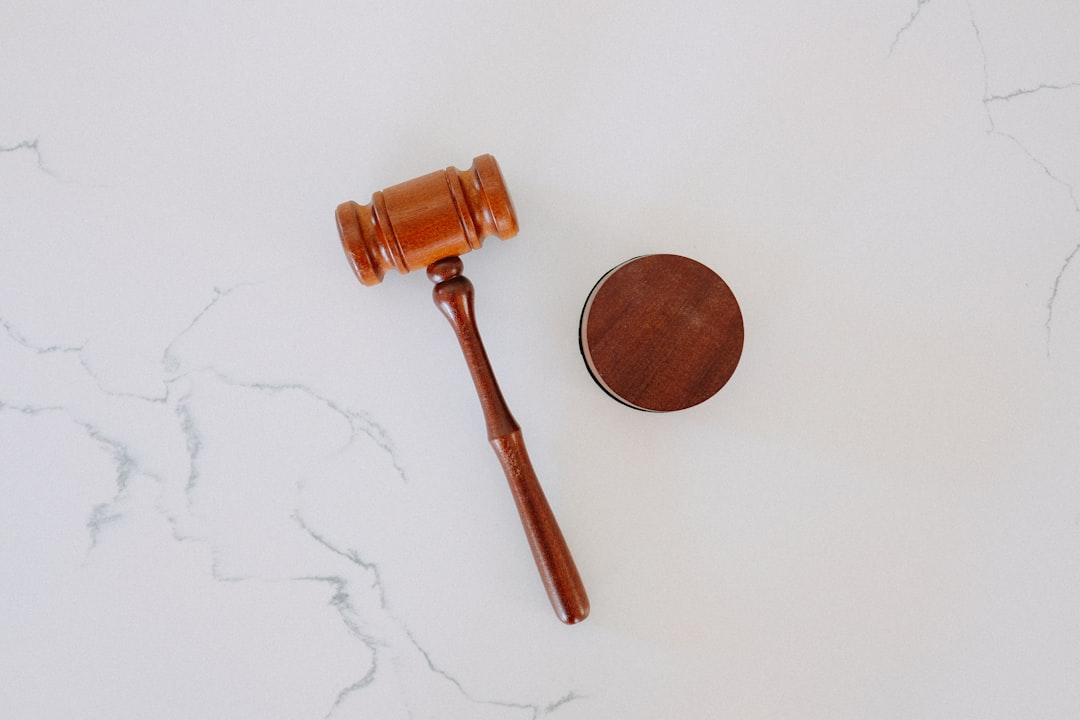 A wooden gavel and sound block rest elegantly on a white marble surface, symbolizing the importance of regulatory compliance in upholding justice.