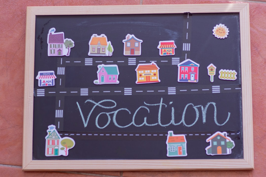 A chalkboard showcases a whimsical street drawing with colorful building stickers and "Vocation" penned in cursive, capturing the charm of traditional media.