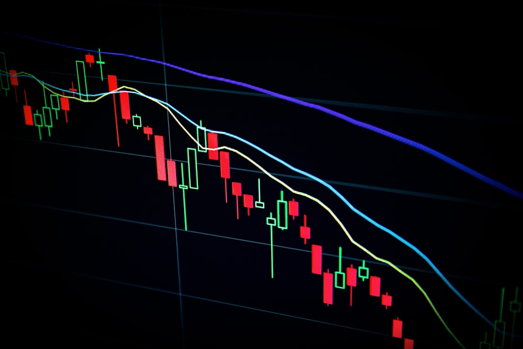 A financial chart reminiscent of those found in financial press releases, depicts a sequence of red and green candlesticks that highlight a downward trend. It features three colored moving average lines elegantly displayed against a stark black background.