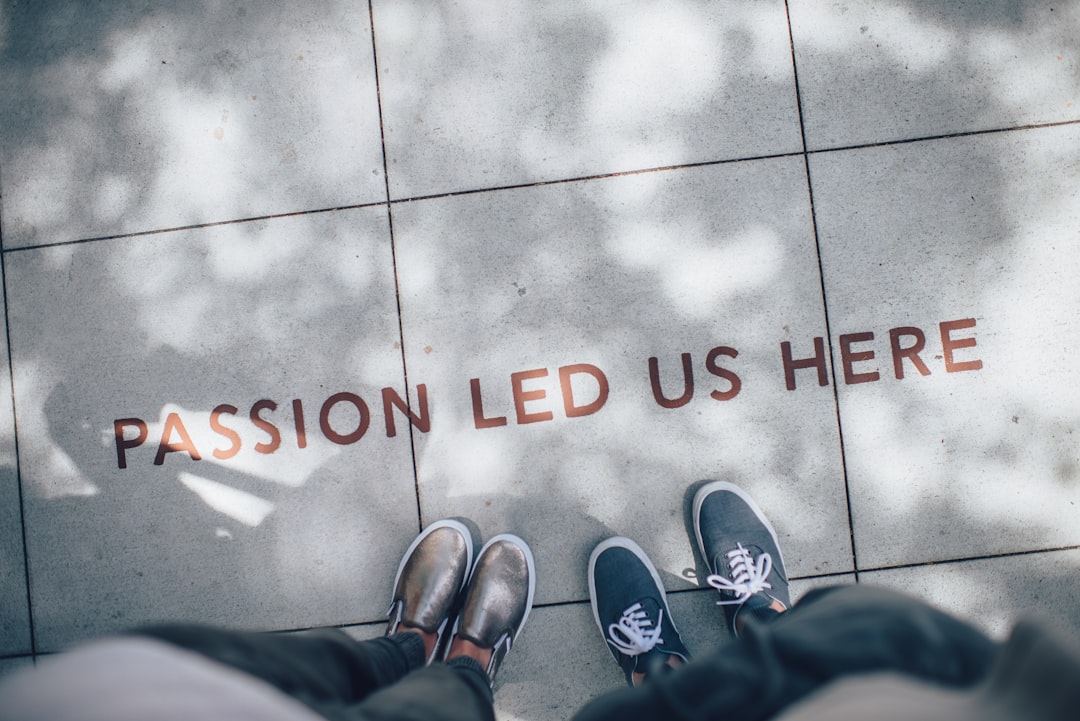 Two pairs of shoes stand on a sidewalk with the words "Passion led us here" etched into the pavement, embodying a financial UVP that speaks to ambition and dedication.